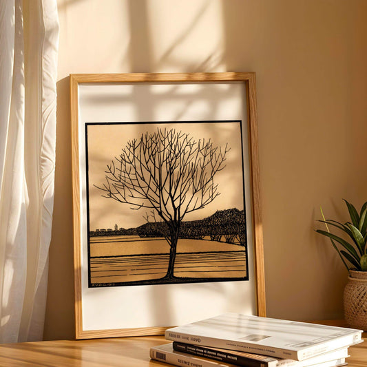 Framed artwork of a tree on a wall with books and a plant below