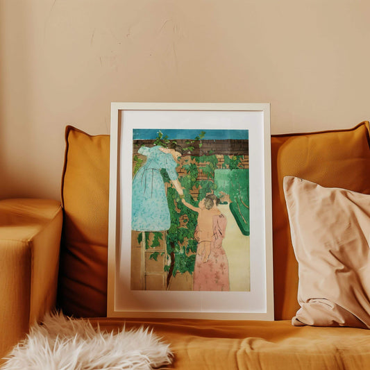 Framed artwork of two women in a garden on a beige wall with brown cushions.