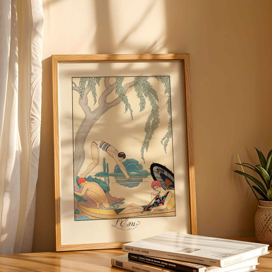 Framed artwork of a woman in a bikini by a pool with a tree, placed on a surface with books and a plant.