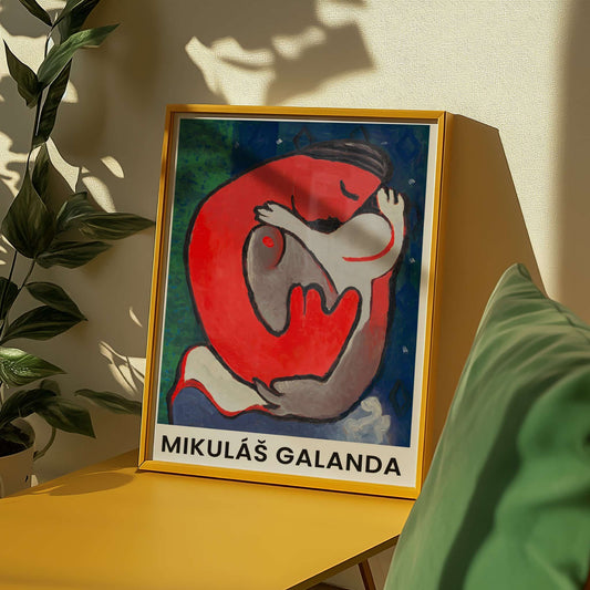 Framed artwork by Mikulas Galanda on a yellow surface with a plant in the background