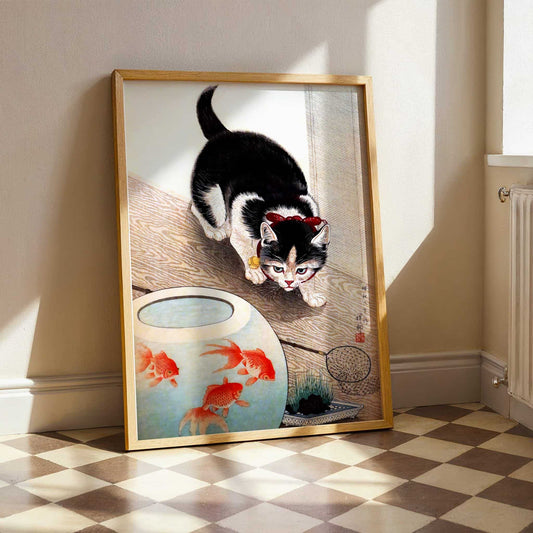 Framed artwork of a cat and goldfish on a checkered floor. Cat and Goldfish Bowl by Ohara Koson