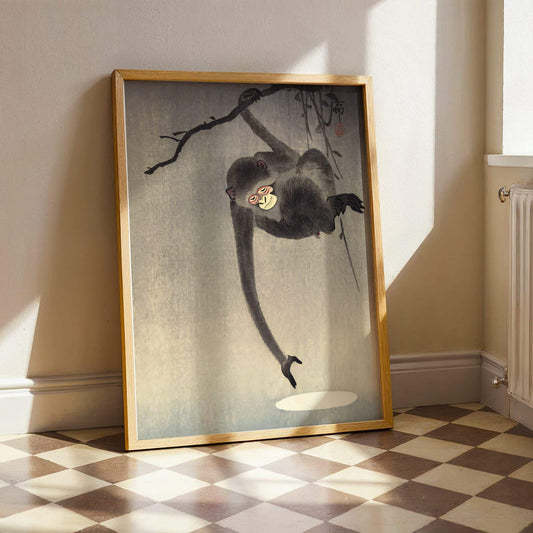 Monkey Reaching for the Moon by Ohara Koson. Framed artwork of a monkey on a branch in a room with checkered floor and radiator.