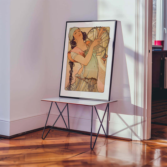 Salome by Alfons Mucha. Framed artwork on a stand in a room with wooden flooring and a window.