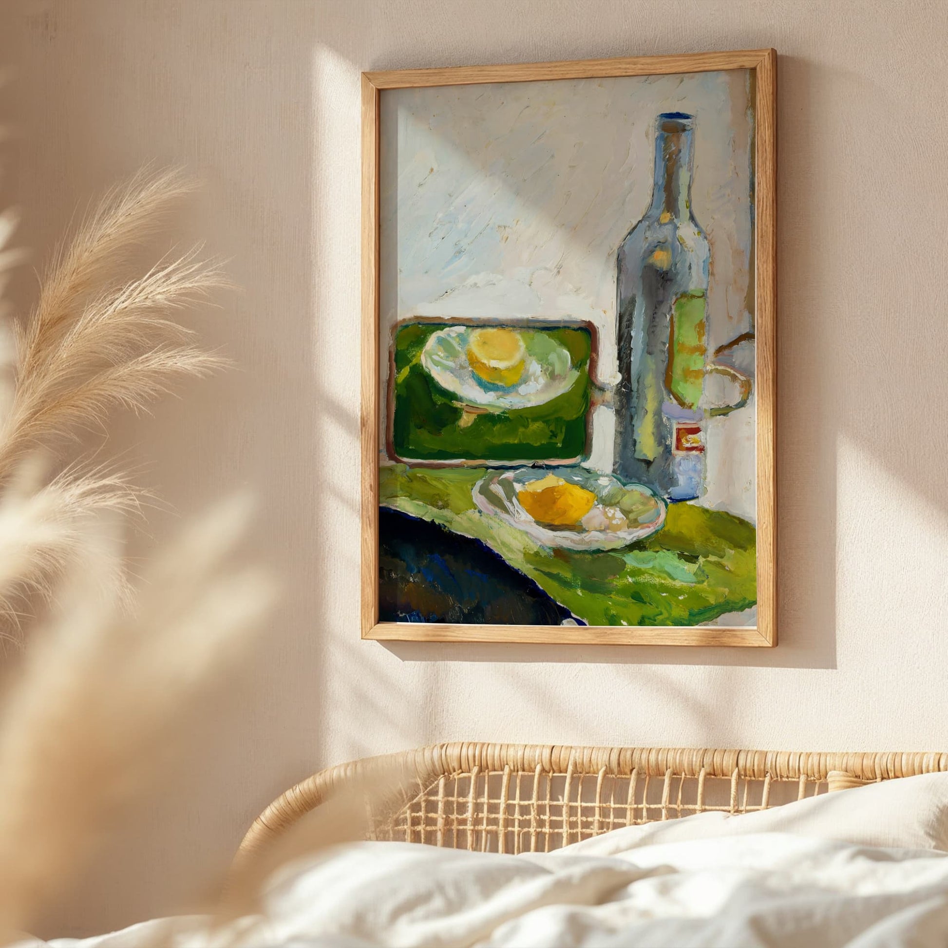 Framed still life painting on a wall with a wicker chair and pampas grass in the foreground.