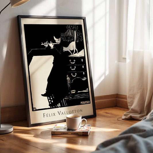 Framed artwork of a black and white illustration on a wooden surface with a cup and book. The Flute by Félix Vallotton