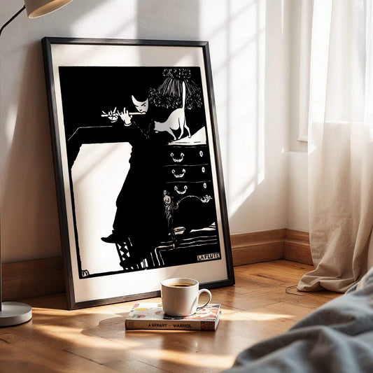 Framed black and white artwork on a wall with a cup of coffee and book on a surface below. The Flute by Felix Vallotton woodblock.