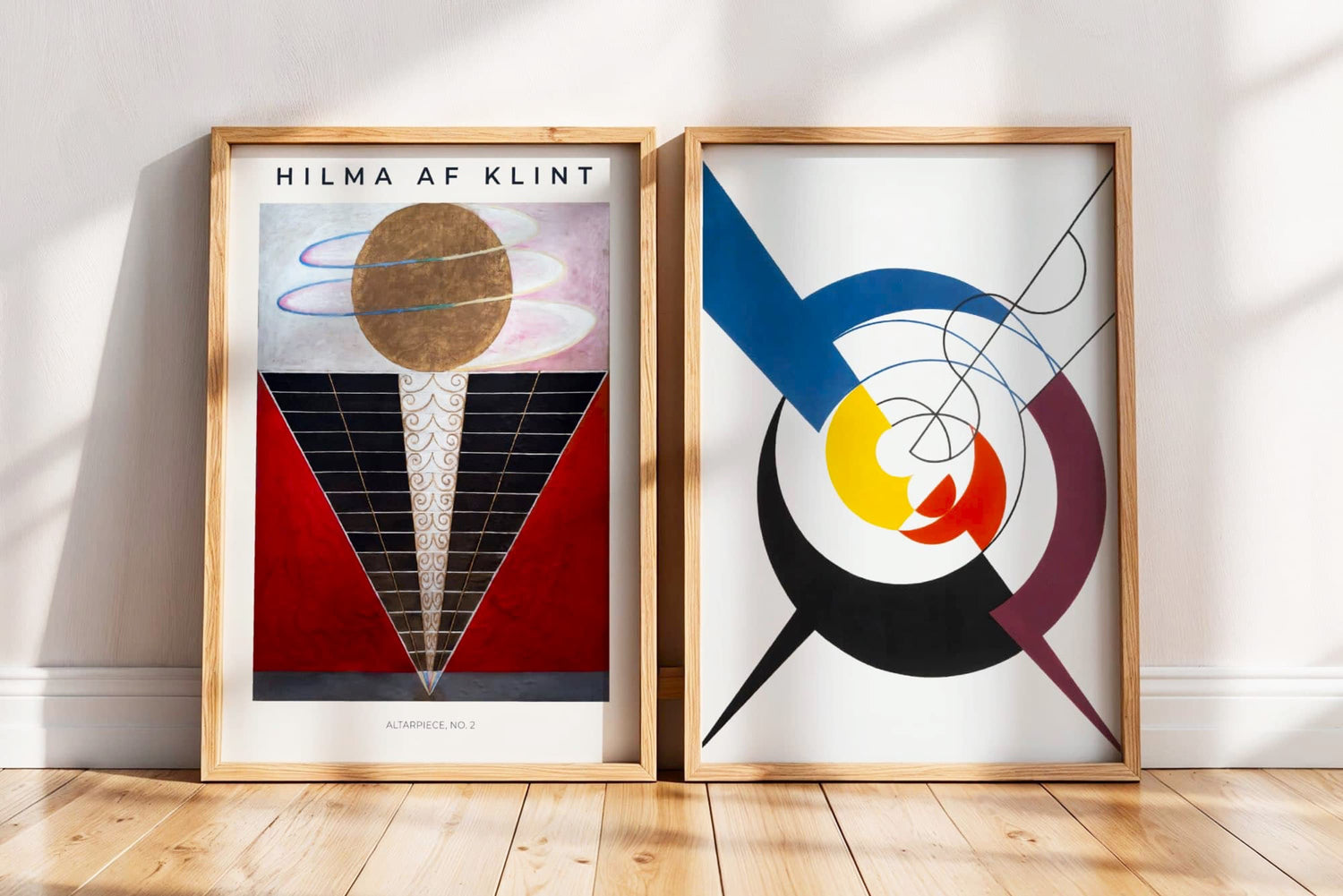 Two framed abstract artworks by Hilma af Klint on a wall with wooden flooring.