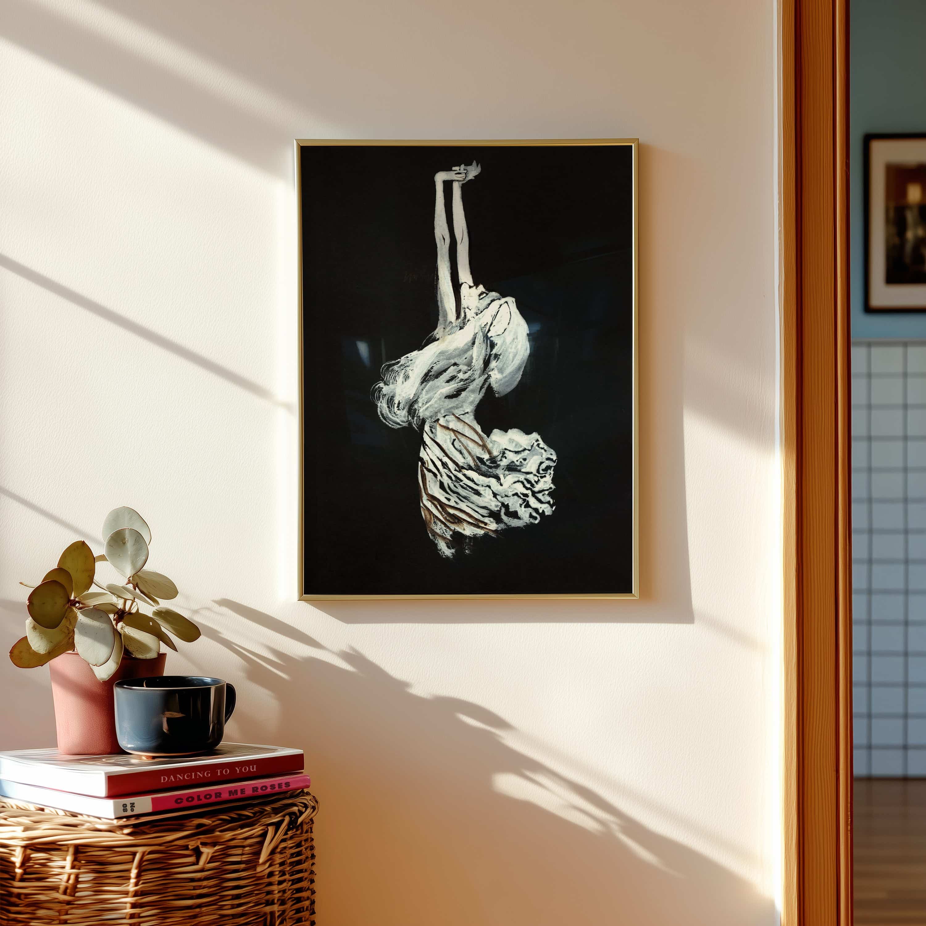 Framed artwork of a abstract white sculpture on a black background, placed on a wall with a plant and books below.